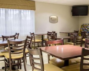 een eetkamer met tafels en stoelen en een tv bij Sleep Inn -Daytona Beach I-95 Exit 268 in Ormond Beach