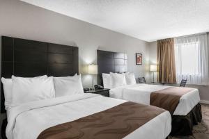 a hotel room with two beds and a window at Quality Inn & Suites By The Lake in Orlando