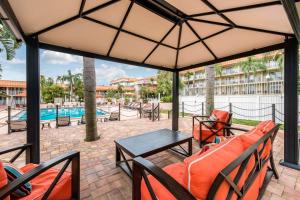 a patio with a table and chairs and a pool at Quality Inn & Suites Tarpon Springs South in Tarpon Springs