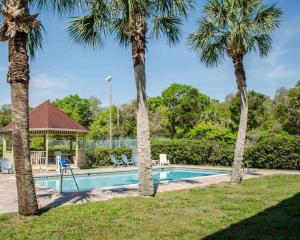 a pool with palm trees and a gazebo at Quality Inn Crystal River in Crystal River