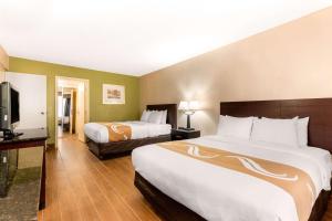 Habitación de hotel con 2 camas y TV de pantalla plana. en Quality Inn & Suites Orlando Airport, en Orlando