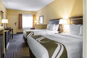 a hotel room with two beds and two lamps at Mi Casa Hotel in Orlando