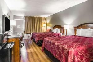 um quarto de hotel com duas camas e uma televisão de ecrã plano em Econo Lodge North em Tallahassee