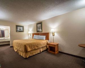 フォートピアースにあるRodeway Inn Fort Pierce I-95のベッドとテーブルが備わるホテルルームです。