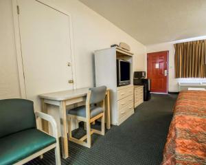 Habitación de hotel con escritorio y cama en Rodeway Inn Gainesville - University Area, en Gainesville