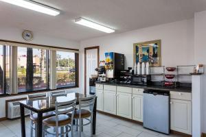 a kitchen with a table and chairs and a counter top at Rodeway Inn Lake City I-75 in Lake City