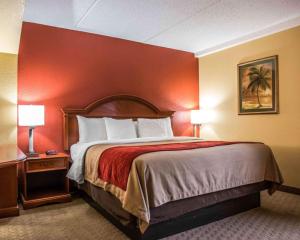 a bed in a hotel room with a red wall at Comfort Inn & Suites Panama City - St Andrew in Panama City