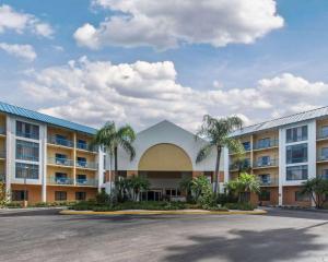 a building with palm trees in front of a parking lot at Comfort Inn Naples East I-75 in Naples