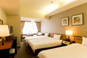 Postel nebo postele na pokoji v ubytování Ryukyu Sun Royal Hotel
