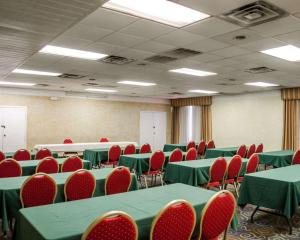 uma sala de conferências com mesas verdes e cadeiras vermelhas em Quality Inn & Suites on the Bay near Pensacola Beach em Gulf Breeze