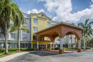 a hotel building with an archway in front of it at Comfort Suites Sawgrass in Tamarac