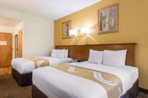 
a hotel room with two beds and two lamps at Quality Inn & Suites Near the Theme Parks in Orlando
