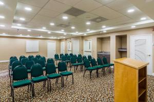 una sala de conferencias con sillas verdes y un podio en Comfort Inn Pensacola - University Area en Pensacola