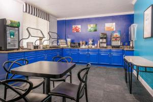 een keuken met blauwe kasten en een tafel en stoelen bij Quality Inn & Suites Near the Theme Parks in Orlando