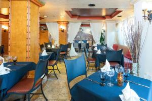 un comedor con mesas y sillas azules en Castillo Real Resort Hotel, en St. Augustine Beach