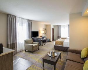 a hotel room with a bed and a living room at Comfort Suites Miami Airport North in Miami