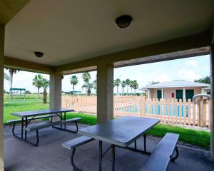 two picnic tables and benches on a patio with a fence at Rodeway Inn & Suites Haines City in Haines City