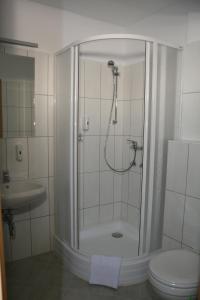 a bathroom with a shower with a toilet and a sink at Panoráma Panzió in Matrafured