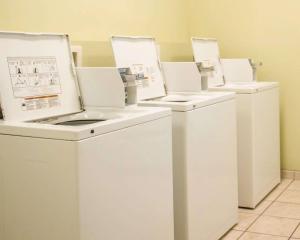 a row of white washing machines in a laundry room at Suburban Studios near Panama City Beach in Panama City