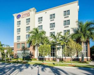 un hotel con palmeras frente a un edificio en Comfort Suites Miami Airport North en Miami