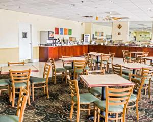 a dining room with tables and chairs and a bar at Quality Inn & Suites Winter Park Village Area in Orlando