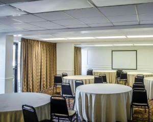 una sala de conferencias con mesas, sillas y una pantalla en Quality Inn & Suites Pensacola Bayview, en Pensacola