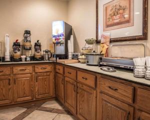 - une cuisine avec des placards en bois et un comptoir dans l'établissement Quality Inn Lake City, à Salt Lake City