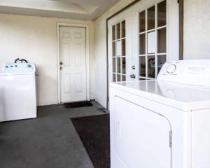 a white laundry room with a washer and dryer at Rodeway Inn Apopka South in Orlando