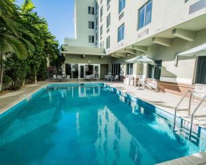 a swimming pool in front of a building at Comfort Suites Miami Airport North in Miami