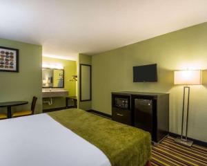 Habitación de hotel con cama y TV de pantalla plana. en Sunset Palm Hotel, en Davenport