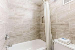a bathroom with a white tub and a toilet at Rodeway Inn Fairgrounds-Casino in Tampa +10 photos