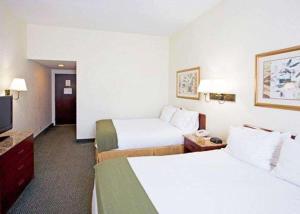 a hotel room with two beds and a flat screen tv at Econo Lodge in Wesley Chapel