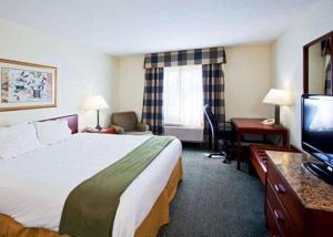 a hotel room with a bed and a desk and a television at Econo Lodge in Wesley Chapel