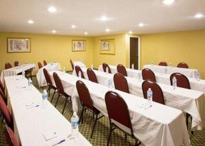 uma sala de conferências com mesas brancas e cadeiras com garrafas de água em Econo Lodge em Wesley Chapel