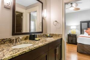 a bathroom with two sinks and a large mirror at Bluegreen Vacations The Fountains, Ascend Resort Collection in Orlando