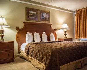 a hotel room with a bed with two lamps and two tables at Rodeway Inn Near Ybor City - Casino in Tampa +44 photos