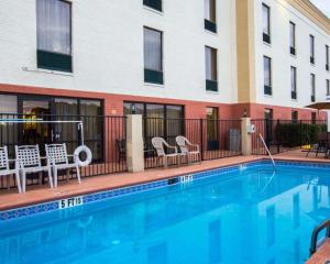 a swimming pool at a hotel with chairs and a building at Comfort Suites Cumming-Atlanta near Northside Hospital Forsyth in Cumming