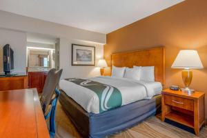 a hotel room with a bed and a desk and a table at Quality Inn Savannah Historic District in Savannah