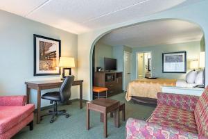 a hotel room with a bed and a desk at Quality Inn Columbus in Columbus