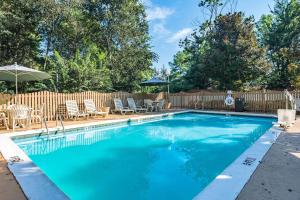 - une piscine avec des chaises et un parasol dans l'établissement Quality Inn Columbus, à Columbus