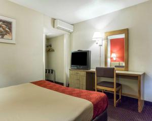 アトランタにあるEcono Lodge Atlanta College Parkのベッドと机とテレビがあるホテルの部屋