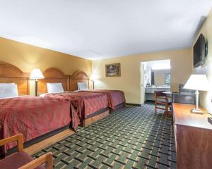 una camera d'albergo con due letti e una scrivania di Econo Lodge Dalton West a Dalton