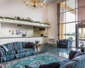 un ampio soggiorno con divani e lampadario a braccio di Econo Lodge Dalton West a Dalton