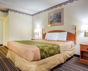 - un grand lit dans une chambre d'hôtel avec 2 lampes dans l'établissement Rodeway Inn Stone Mountain, à Tucker