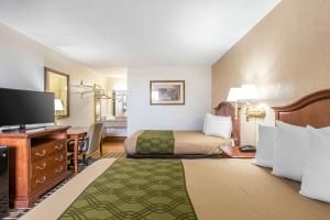 um quarto de hotel com uma cama e uma televisão de ecrã plano em Econo Lodge Midtown em Savannah