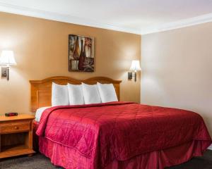 a hotel room with a bed with a red bedspread at Quality Inn & Suites Atlanta Airport South in Atlanta