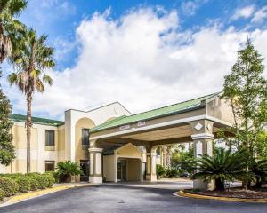 un bâtiment d'hôtel avec un parking et des palmiers dans l'établissement Quality Inn Darien-North Brunswick, à Darien