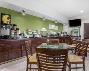 a restaurant with a table and chairs and a counter at Days Inn by Wyndham McDonough in McDonough