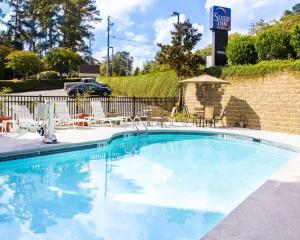 uma grande piscina com cadeiras e um guarda-sol em Sleep Inn & Suites Columbus State University Area em Columbus
