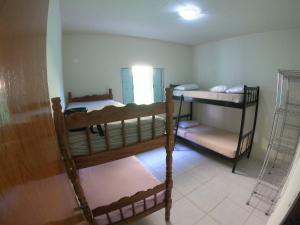Zimmer mit 2 Etagenbetten und einem Fenster in der Unterkunft Lugar tranquilo na praia in Ubatuba